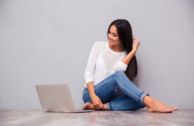 laptop ile katta oturan mutlu kız 