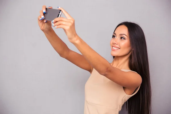 Женщина в платье делает селфи фото на смартфоне — стоковое фото