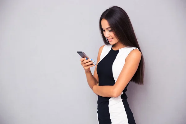 Leende kvinna i klänning med smartphone — Stockfoto