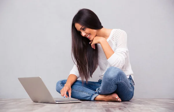 Kobieta siedzi na podłodze i przy użyciu laptopa — Zdjęcie stockowe