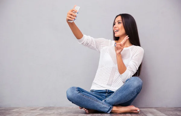 Kvinna sitter på golvet och att göra selfie Foto — Stockfoto