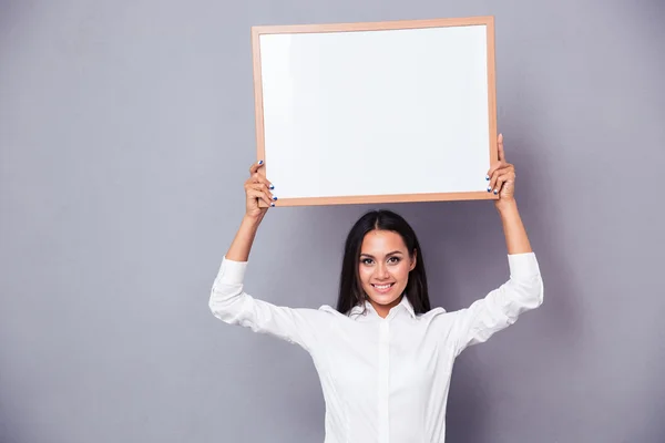 Portrait of a happy woman holding blank board on head — Stock Photo, Image