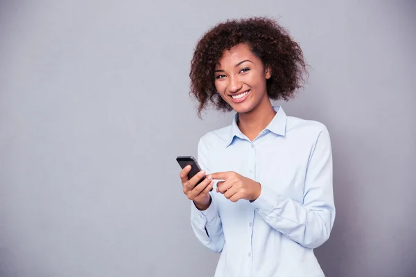 Afro american woman using smartphone and looking at camera — Stock Photo, Image