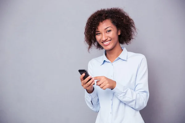 Afro american woman using smartphone and looking at camera — Stok Foto