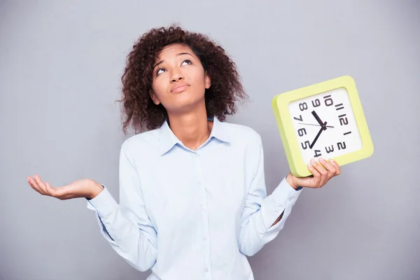 Cansado afro-americano mulher segurando relógio — Fotografia de Stock