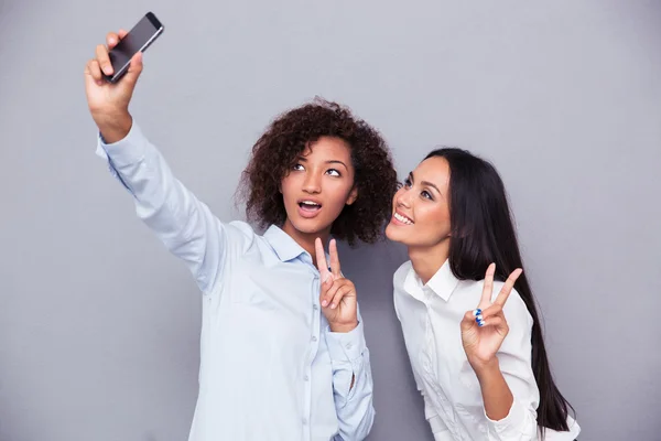 Happy two girls making selfie photo on smartphone — Stock Photo, Image