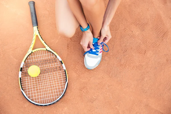 Tennis player tying shoelaces — Stock Photo, Image