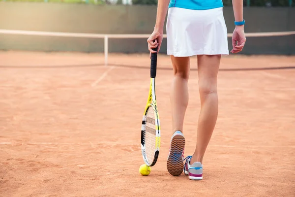 Vrouwelijke poten met tennisracket — Stockfoto