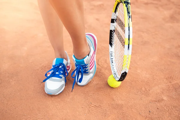 Vrouwelijke poten met tennisracket — Stockfoto