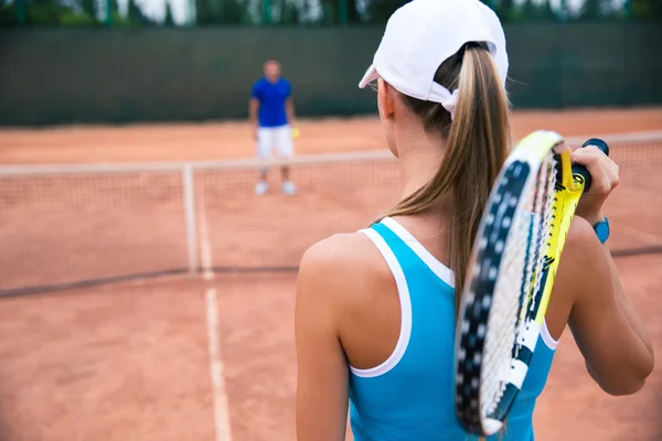 Woman playing in tennis with man outdoors — Stock Photo, Image