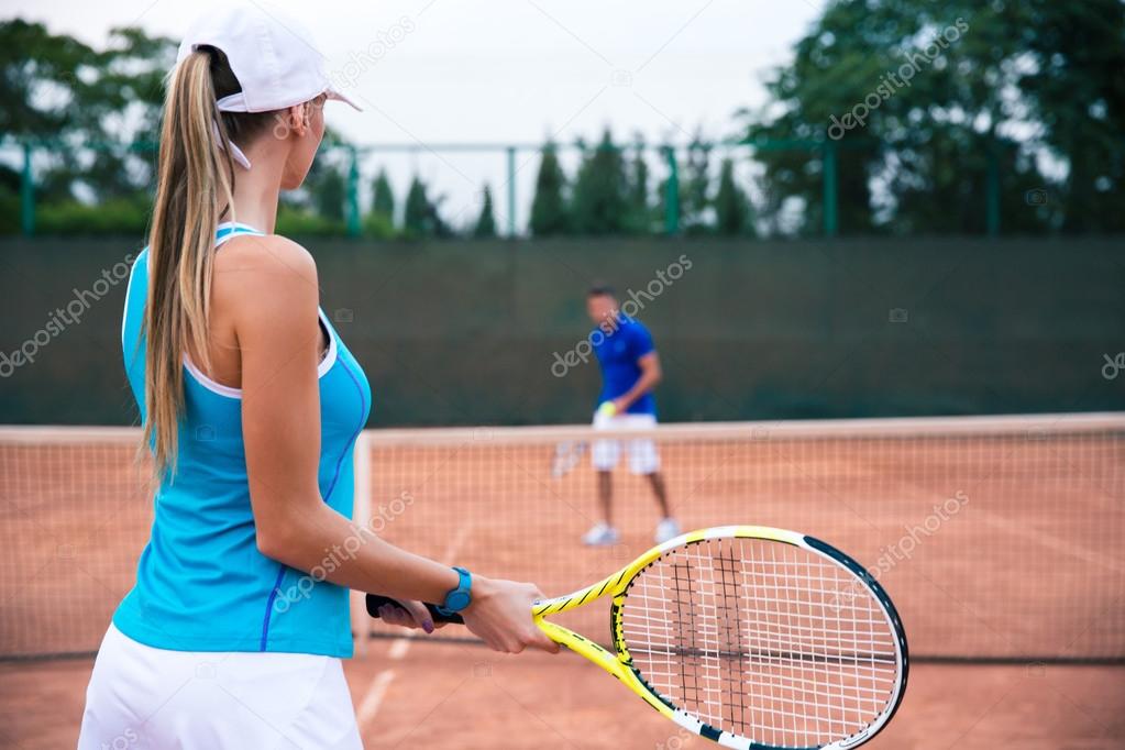 Woman playing in tennis with man outdoors