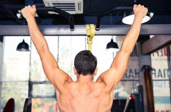 Man tightening on horizontal bar — Stock Photo, Image