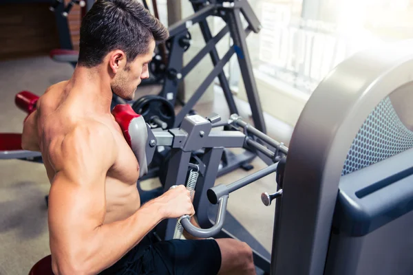 Man doen oefening op fitness machine in gym — Stockfoto