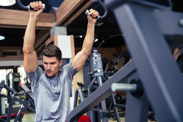 Ajuste o treino do homem na máquina de fitness — Fotografia de Stock