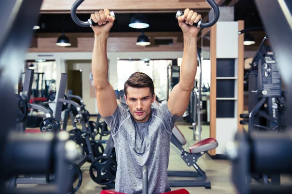 Bodybuilder doing exercise on a fitness machine — Stock Photo, Image