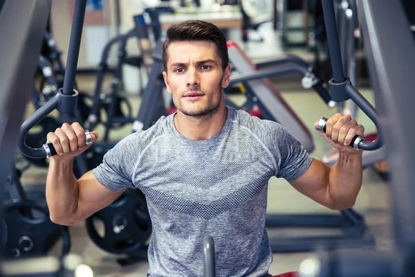 Bodybuilder workout on fitness machine at gym — Stock Photo, Image