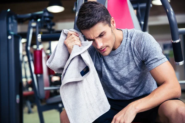 Bodybuilder veegt het zweet in de fitnessruimte — Stockfoto