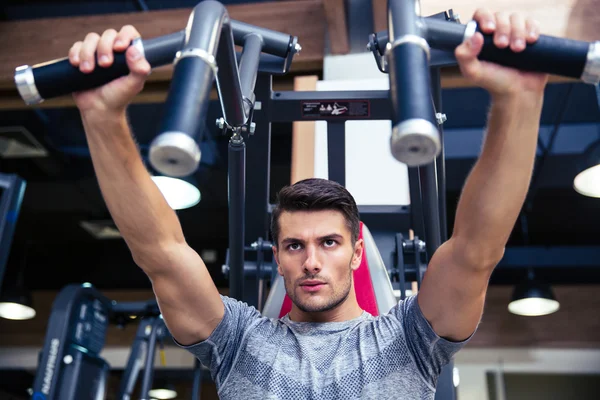 Man doen oefening op fitness machine in gym — Stockfoto