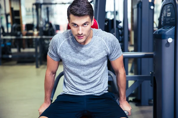 Uomo che fa esercizio su una macchina fitness in palestra — Foto Stock