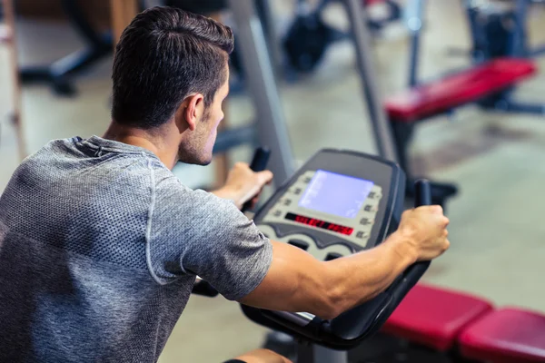 Entrenamiento de hombre en una máquina de fitness —  Fotos de Stock