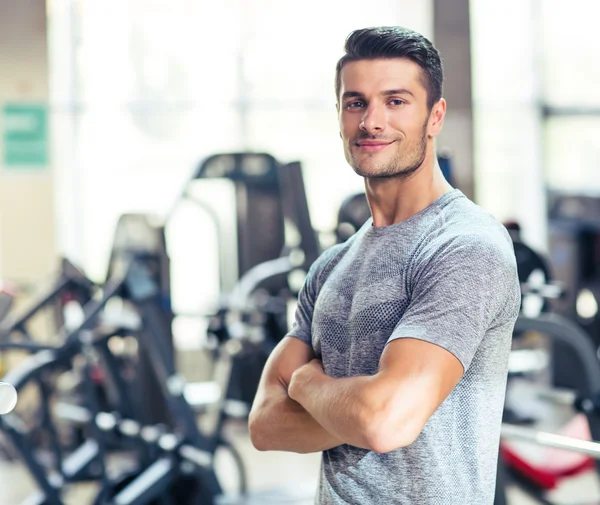 Fitness man standing with arms folded at gy — Stock Photo, Image