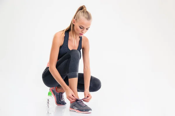 Portrait of a sports woman ties shoelaces — Stock Photo, Image