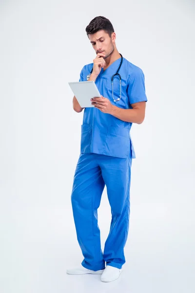 Médico homem pensativo segurando tablet computar — Fotografia de Stock