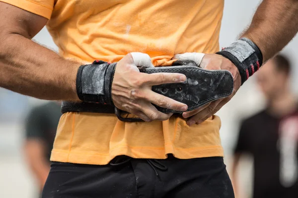 Bodybuilder girding on his bodybuilding belt — Stock Photo, Image