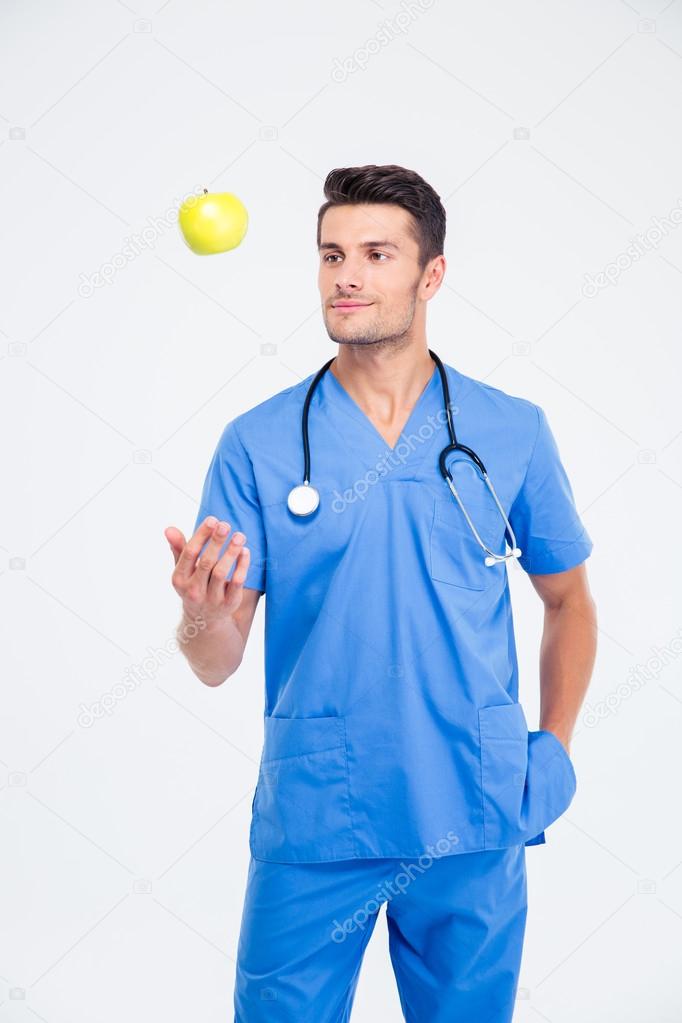 Portrait of a handsome male doctor standing with apple