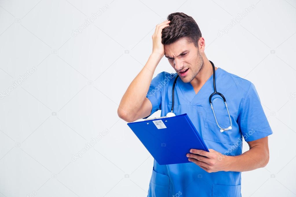 Disappointed male doctor with clipboard