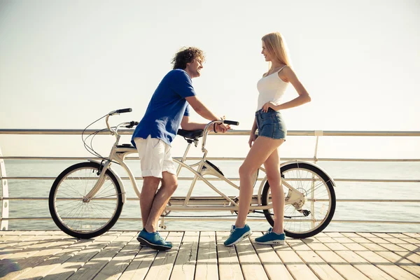 Happy couple standing with bicycle — Stock Photo, Image