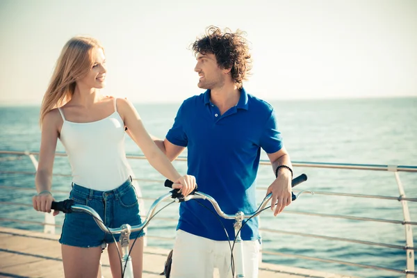 Couple on bicycle talking outdoors Stock Picture