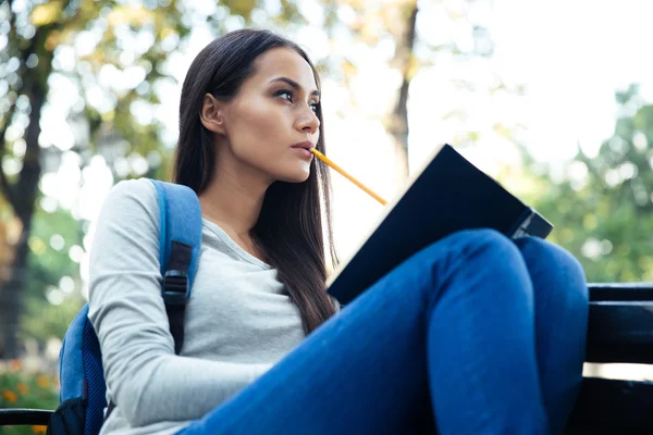 Studentessa seduta sulla panchina con libro — Foto Stock