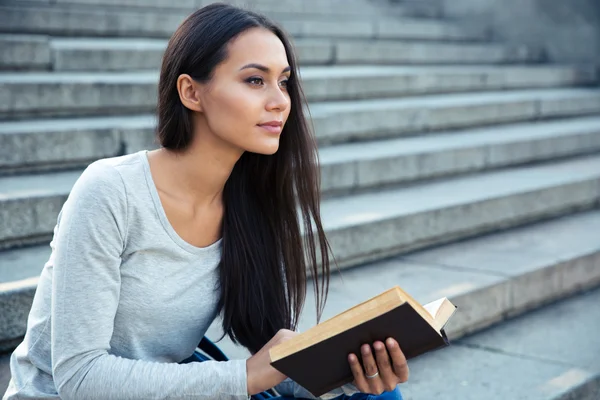 Donna seduta sulle scale della città con libro all'aperto — Foto Stock