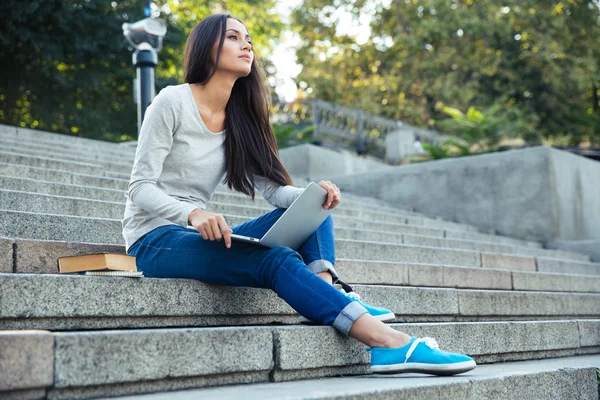 Vrouwelijke student zitten met laptop buiten — Stockfoto