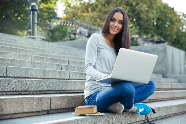 Estudante feminina usando computador portátil ao ar livre — Fotografia de Stock