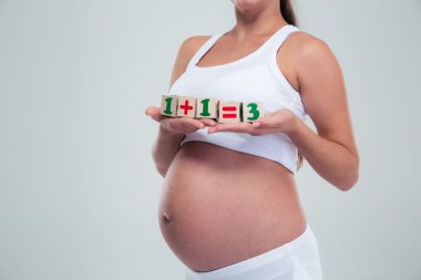 Pregnant woman holding bricks with equation clipart