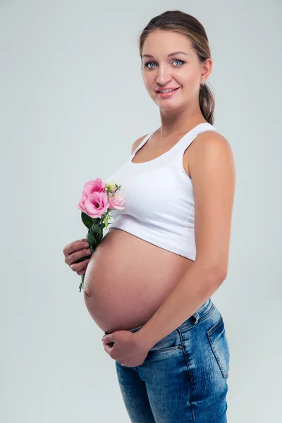 Портрет щасливої вагітної жінки, що тримає квіти — стокове фото
