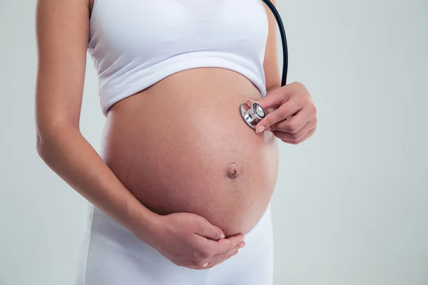 Pregnant woman on 9 month with stethoscope — Stock Photo, Image