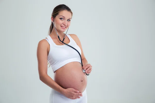 Mujer embarazada siendo examinada con estetoscopio — Foto de Stock