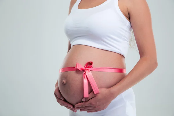 Mujer embarazada con cinta de regalo — Foto de Stock