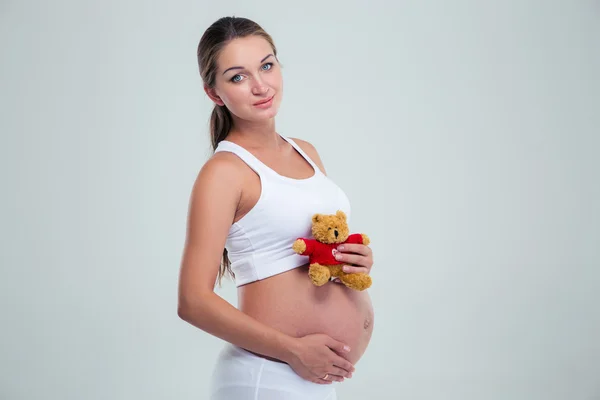 Pregnant woman with teddy bea — Stockfoto