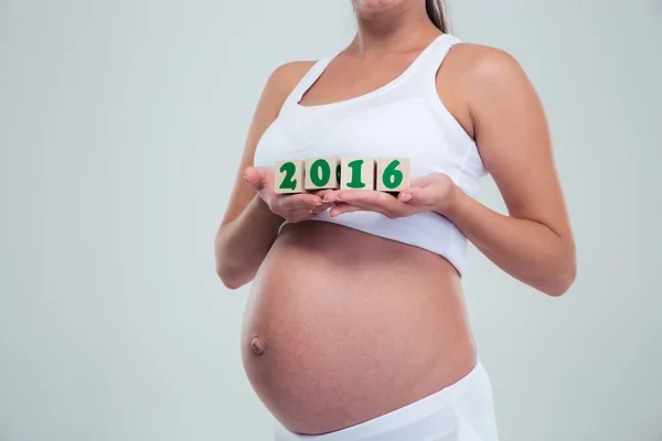 Pregnant woman holding number bricks — Stock Photo, Image