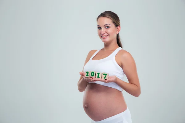 Pregnant woman holding number bricks — Stockfoto