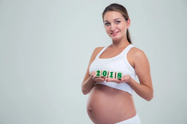 Pregnant woman holding number bricks — Stockfoto