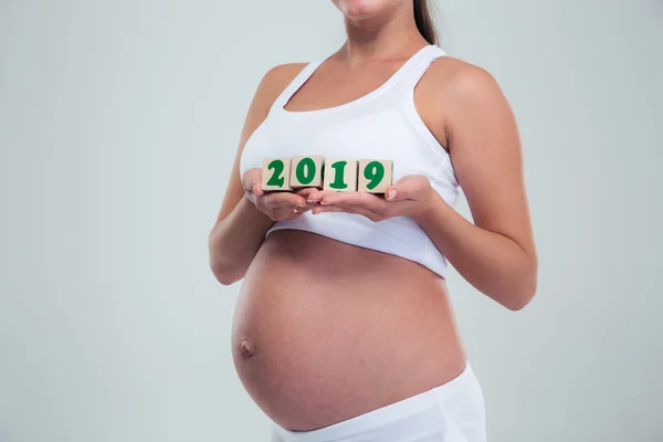 Pregnant woman holding number bricks — Stock Photo, Image