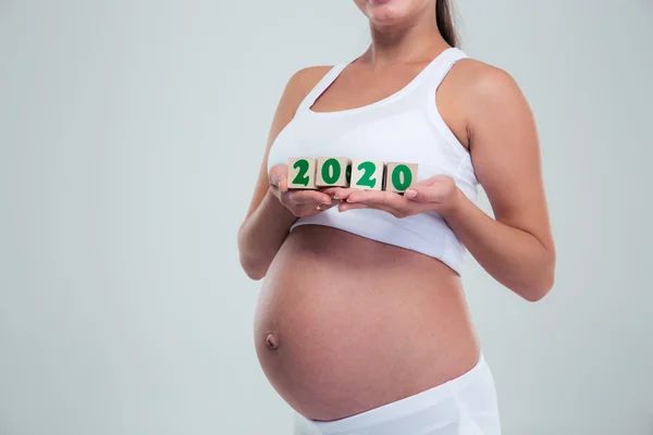 Pregnant woman holding number bricks — Stock Photo, Image