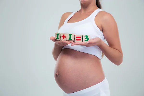 Pregnant woman holding bricks with equation — Stok fotoğraf