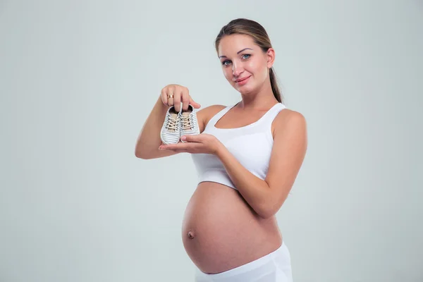 Pregnant woman holding a baby booties — Stock Photo, Image