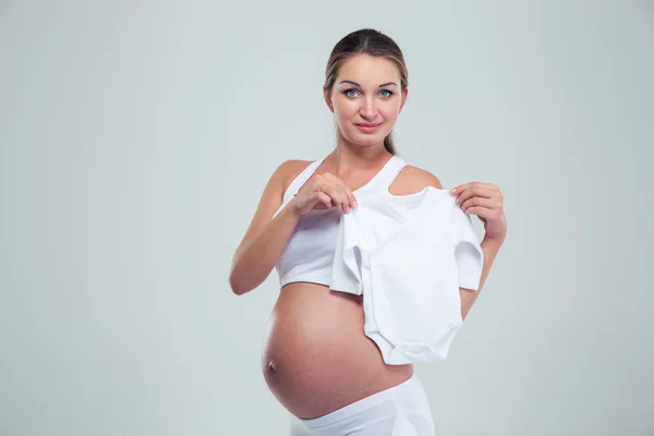 Mujer embarazada sosteniendo una camiseta de bebé — Foto de Stock